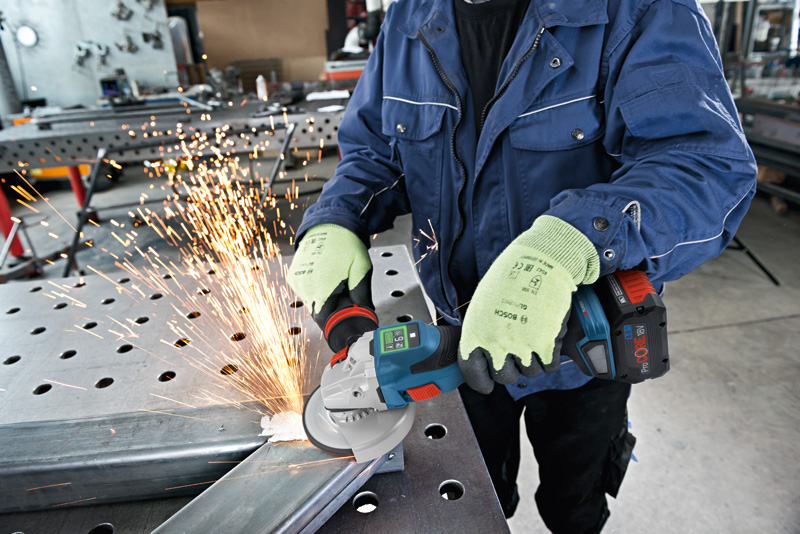 Eine Person mit Schutzausrüstung schleift Metall mit einem Elektrowerkzeug und erzeugt dabei Funken. Anwendungsbild