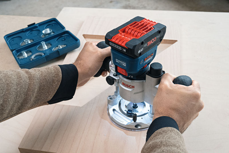 Eine Person verwendet eine kabellose Handfräse, um eine rechteckige Nut in Holz zu formen. Anwendungsbild