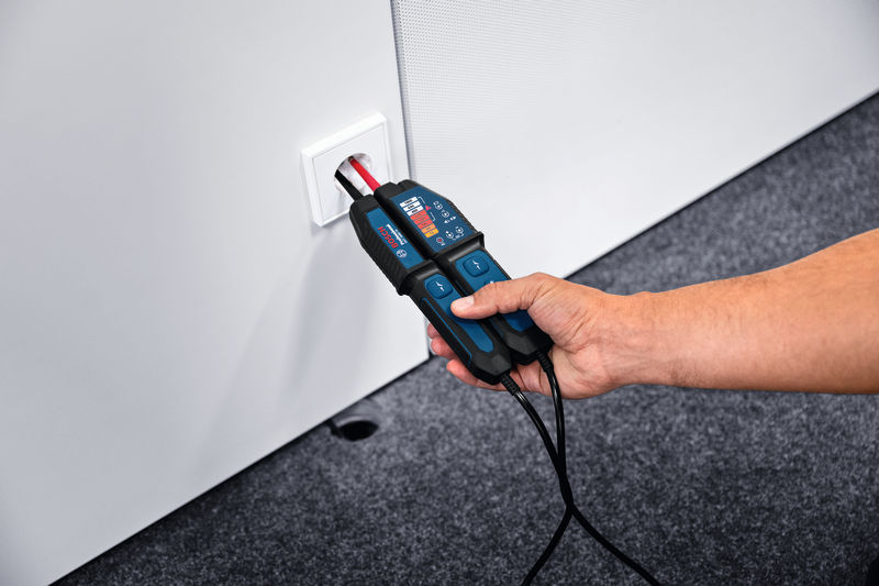 Eine Person verwendet einen Spannungsprüfer, um eine Steckdose zu überprüfen. Anwendungsbild