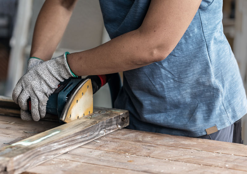 Bosch -Exzenterschleifer zum Glätten eines Holzbretts. Detailbild