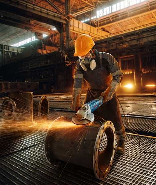 Arbeiter schleift Metallrohre. Anwendungsbild