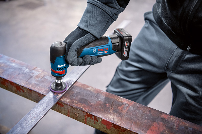Eine Person mit Schutzausrüstung poliert mit einem Rotationsschleifer einen Metallträger. Anwendungsbild