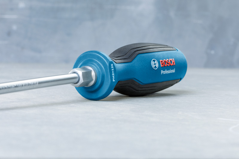 Blau-schwarzer Schraubendreher mit ergonomischem Griff auf einer grauen Oberfläche. Anwendungsbild
