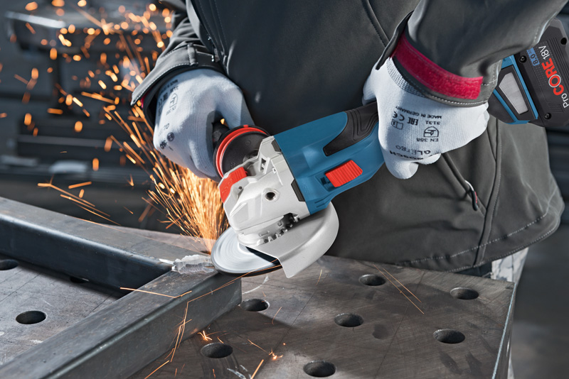 Eine Person mit Schutzausrüstung schleift mit einem Akku-Winkelschleifer einen Metallträger. Anwendungsbild