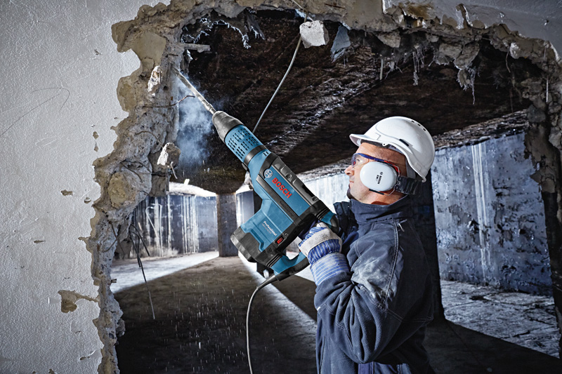 Arbeiter bohrt Betonwand. Anwendungsbild