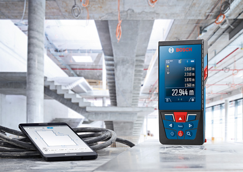 Lasermessgerät und Tablet zeigen Messungen auf einer Betonoberfläche auf einer Baustelle an. Anwendungsbild