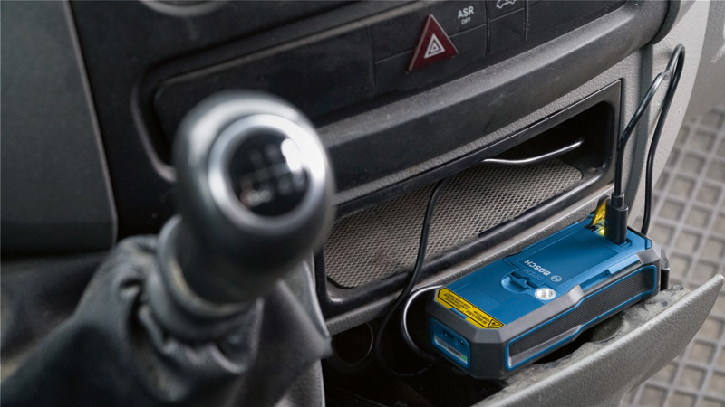 Aufladen des Akkupacks in einer Autokonsole über ein USB-Kabel. Anwendungsbild