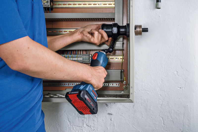 Eine Person verwendet ein kabelloses hydraulisches Stanzwerkzeug an einer Schalttafel. Anwendungsbild