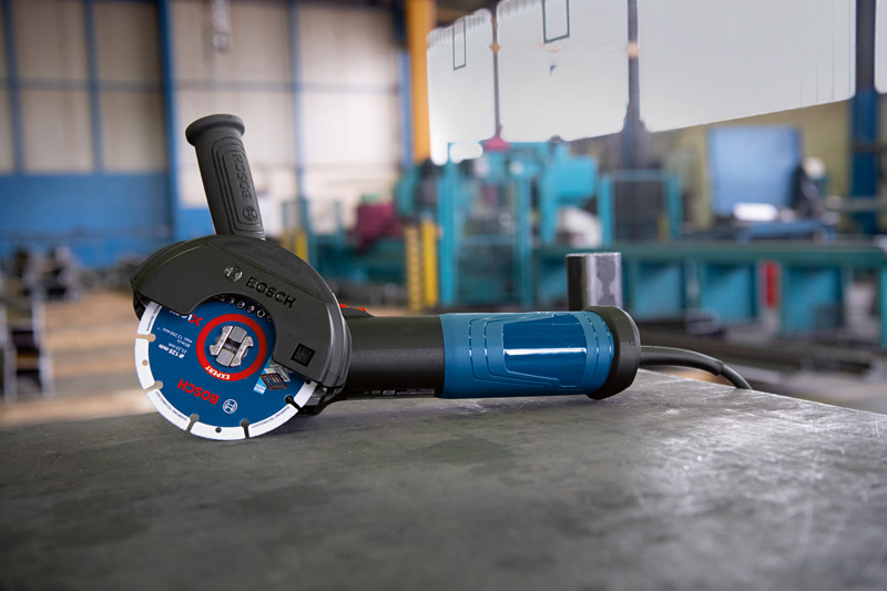 Winkelschleifer mit X-LOCK-System, der auf einer Metallwerkbank in einer Werkstatt ruht. Anwendungsbild