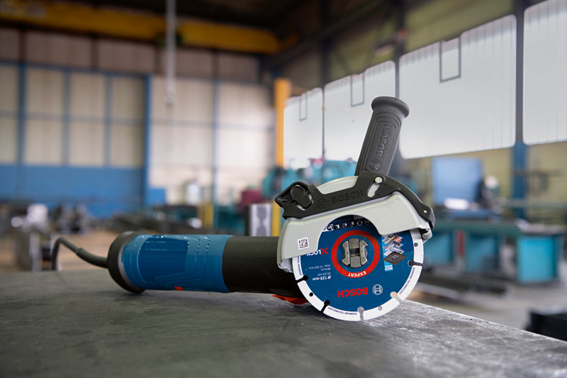 Winkelschleifer mit X-LOCK-System auf einer Werkbank in einer Industriewerkstatt. Anwendungsbild