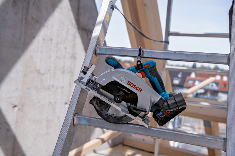 Akku-Kreissäge auf einer Metallleiter auf einer Baustelle. Anwendungsbild